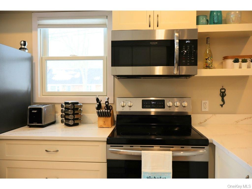 38 Woodridge Road Hampton Bays, NY 11946 - Photo 10 of 24 a kitchen with a stove and a microwave