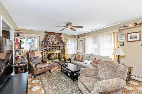 a living room with furniture ceiling fan and a window