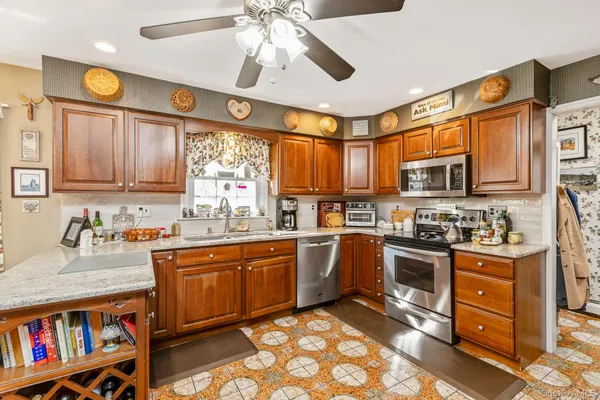 a kitchen with stainless steel appliances granite countertop a sink cabinets and window