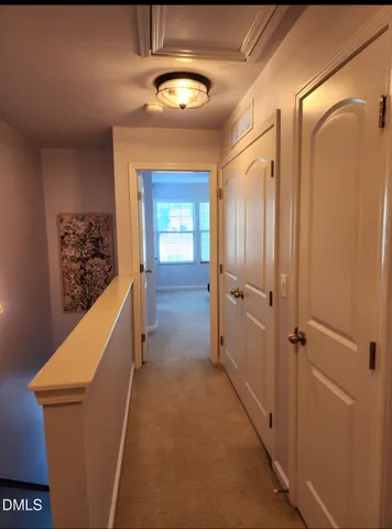 a view of a hallway with wooden cabinets and entryway