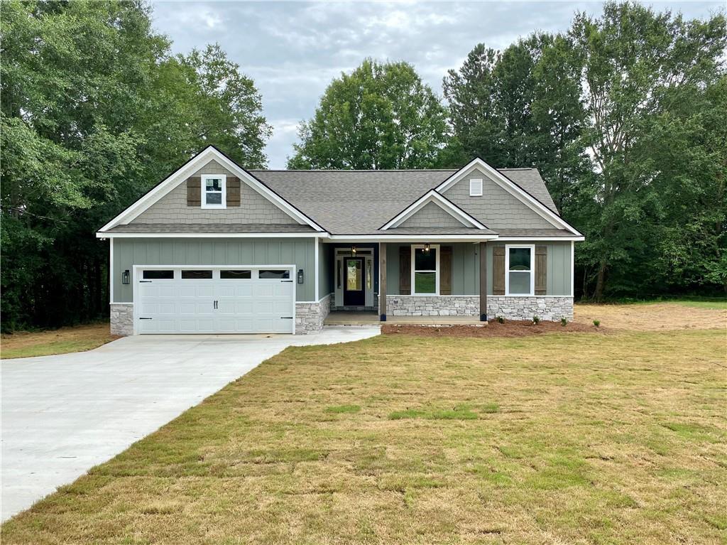 243 Rainey Road Temple, GA 30179 - Photo 1 of 1 a front view of a house with a garden and trees