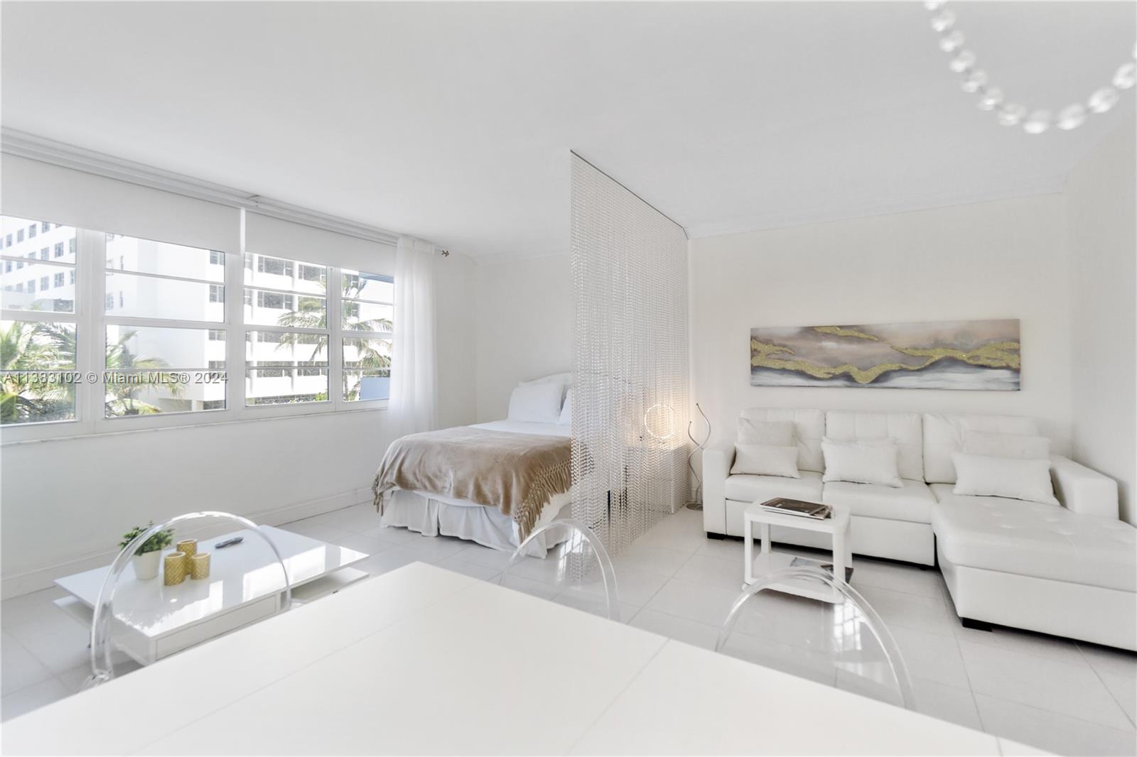 100 Lincoln Road, Unit 306 Miami Beach, FL 33139 - Photo 3 of 18 a bedroom with furniture and a large window