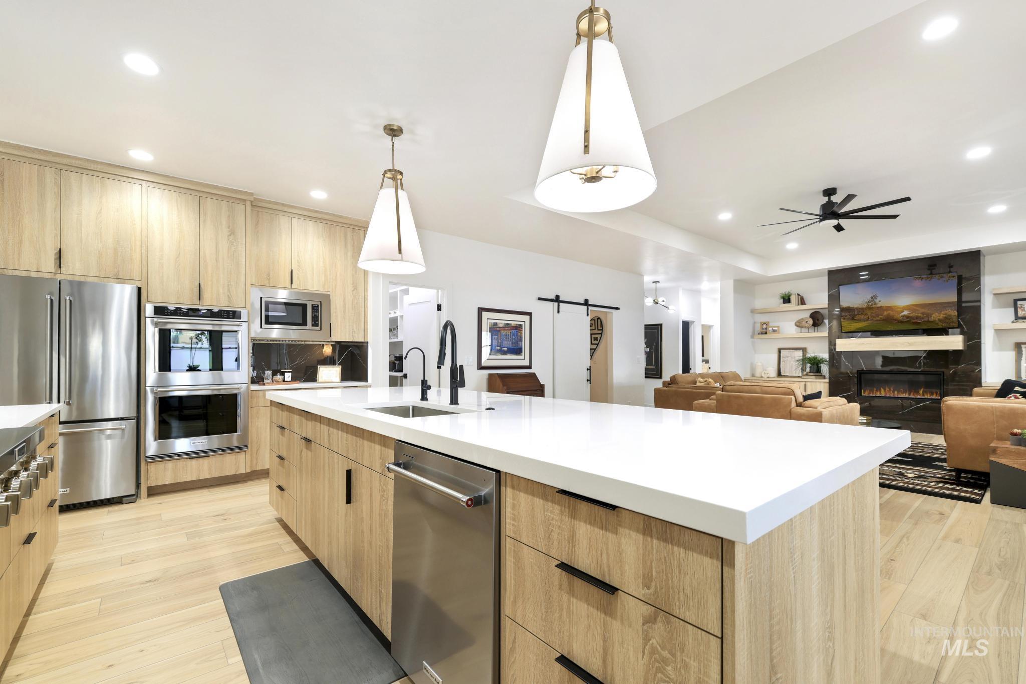 3140 Moonrise Road Twin Falls, ID 83301 - Photo 11 of 39 Kitchen with a barn door, light wood-style flooring, stainless steel appliances, and light wood finish cabinets