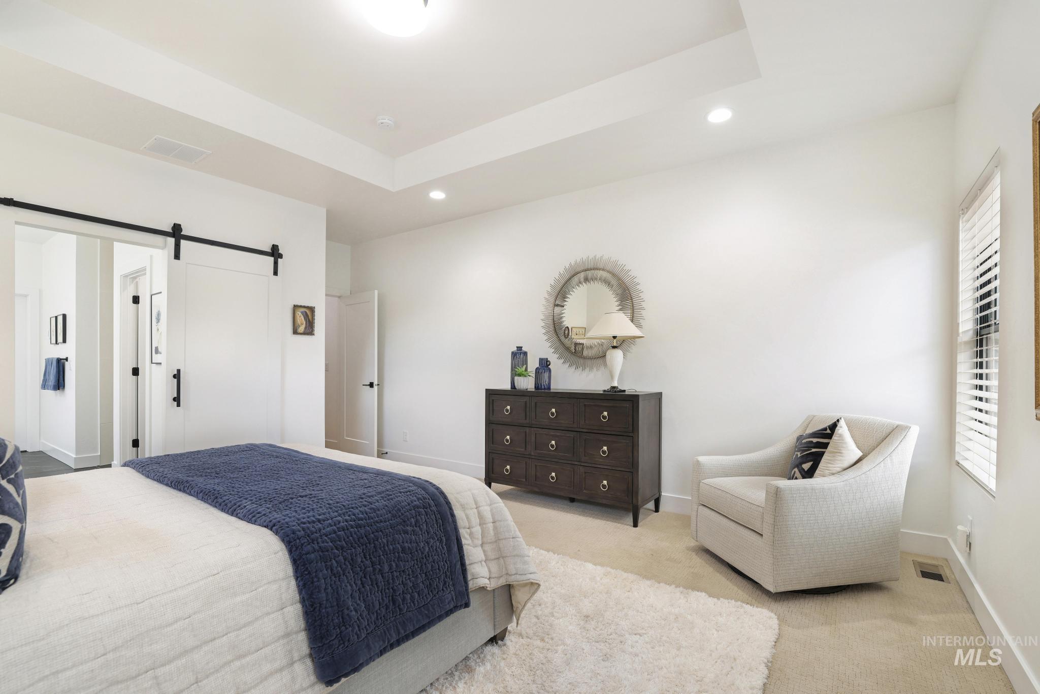 3140 Moonrise Road Twin Falls, ID 83301 - Photo 22 of 39 Bedroom featuring a barn door, carpet flooring, a raised ceiling, and recessed lighting