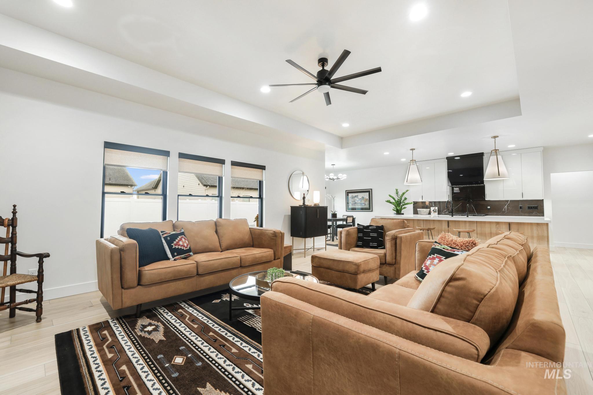 3140 Moonrise Road Twin Falls, ID 83301 - Photo 7 of 39 Living area with light wood-style flooring, a ceiling fan, a raised ceiling, and suspended lighting