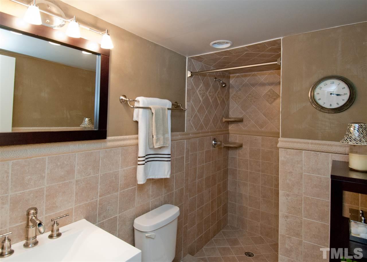 520 Smokeridge Lane Raleigh, NC 27615 - Photo 19 of 25 a bathroom with a shower a mirror and a sink