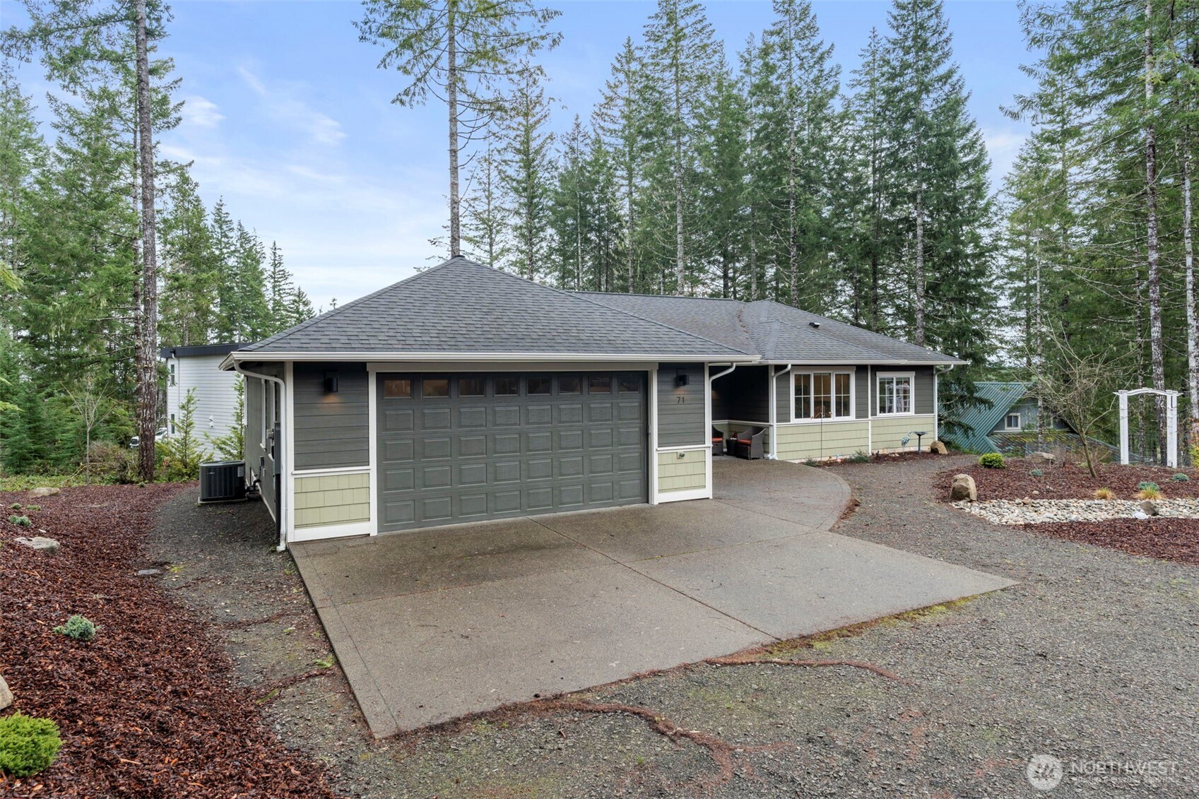 71 East Hemlock Court Union, WA 98592 - Photo 26 of 32 a front view of a house with a garden and trees