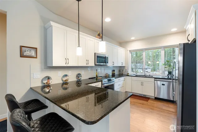 a kitchen with stainless steel appliances granite countertop a sink stove and cabinets