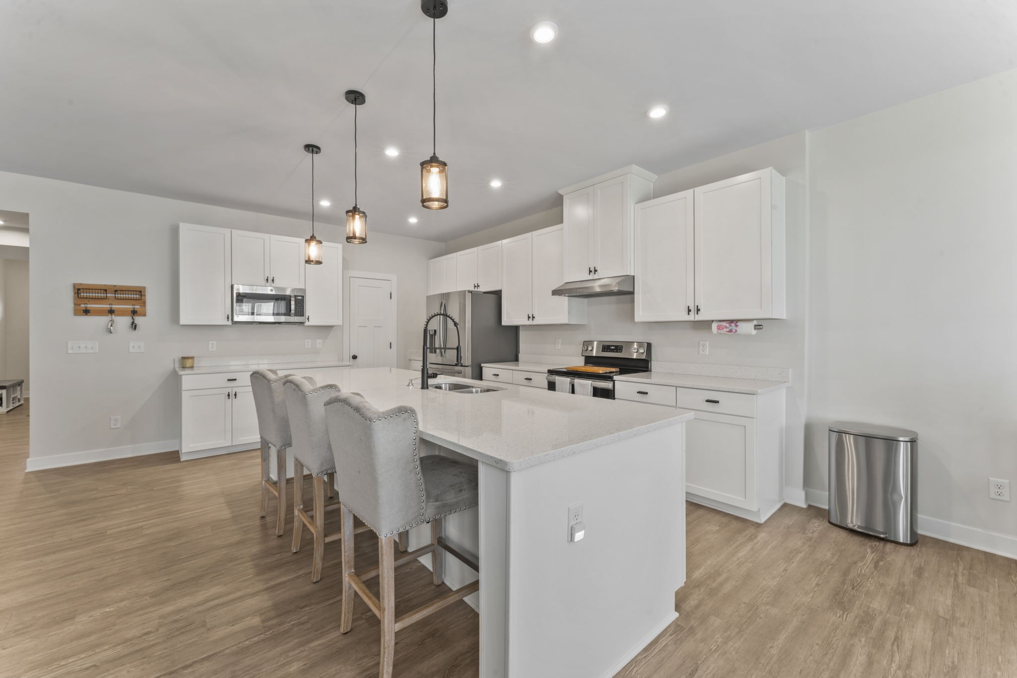 907 Caywood Road Smyrna, TN 37167 - Photo 7 of 32 a kitchen with stainless steel appliances a stove a sink a refrigerator with white cabinets and wooden floor
