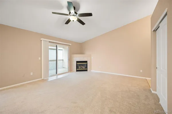 an empty room with windows and ceiling fan