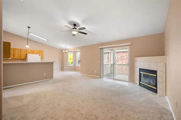 a view of an empty room with a fireplace and a window