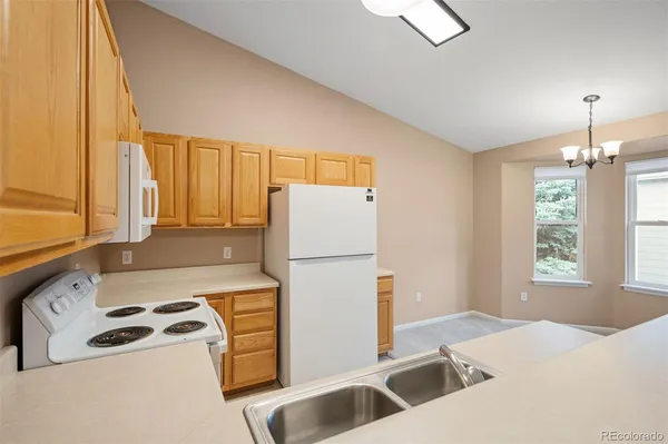 a kitchen with a refrigerator a stove a sink and a window