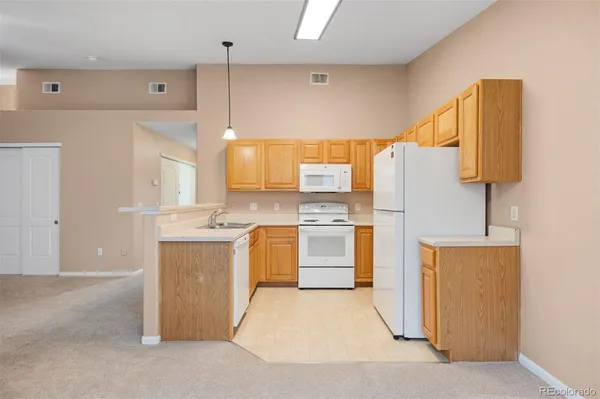 a kitchen with white cabinets and white appliances