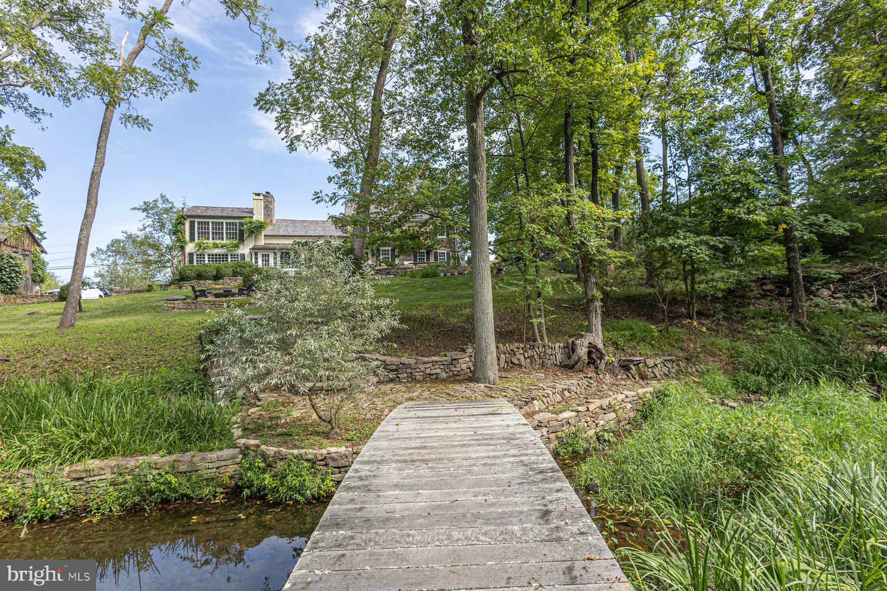 5925 Carversville Road Doylestown, PA 18902 - Photo 31 of 44 a view of a yard with plants and a bench