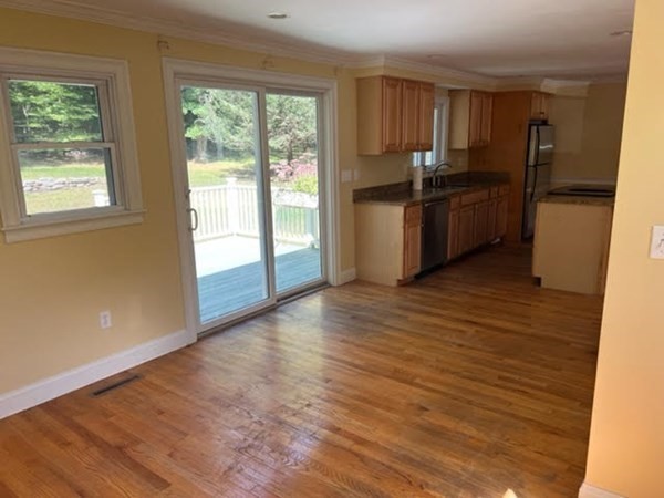 288 Sugar Road Bolton, MA 01740 - Photo 4 of 13 a kitchen with granite countertop a refrigerator and wooden cabinets