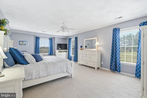 a spacious bedroom with a bed and a chandelier