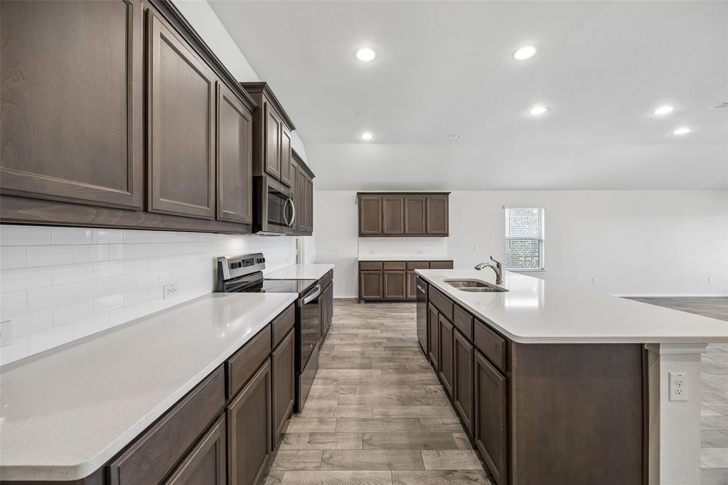 3807 Dogwood Road Melissa, TX 75454 - Photo 6 of 38 a large kitchen with stainless steel appliances lots of counter space and wooden floor