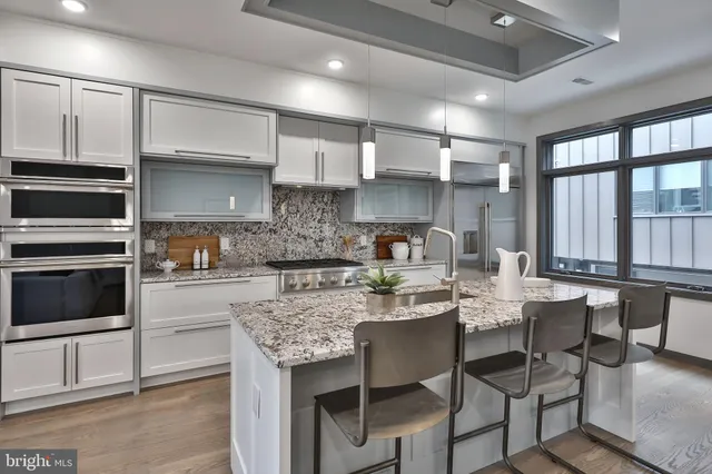 a kitchen with stainless steel appliances granite countertop a sink stove and cabinets