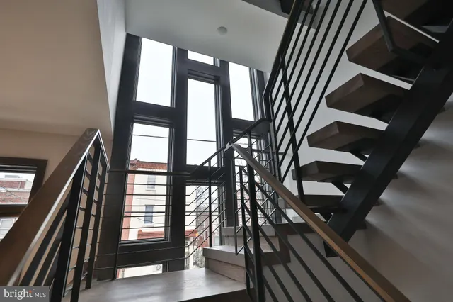 a view of staircase with lots of frames on wall and a window