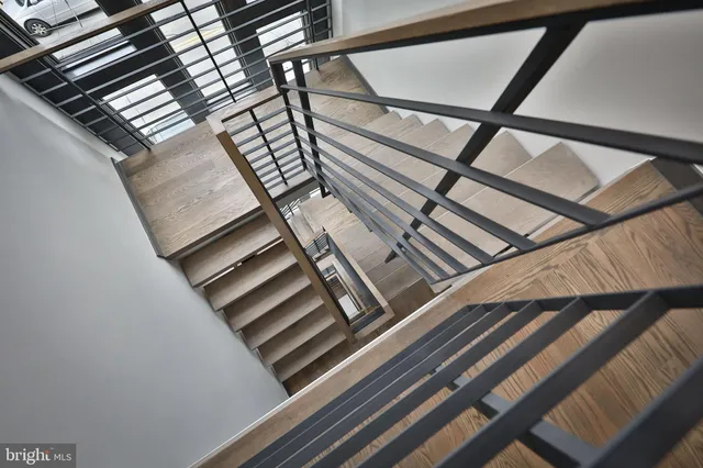 a spacious bedroom with a bed a dresser with wooden floor