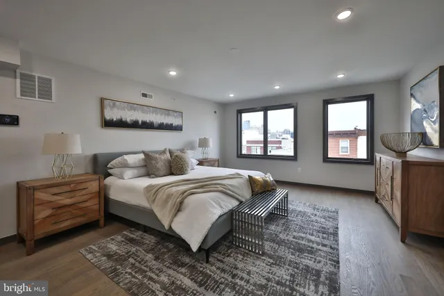 a spacious bedroom with a large bed and a dresser