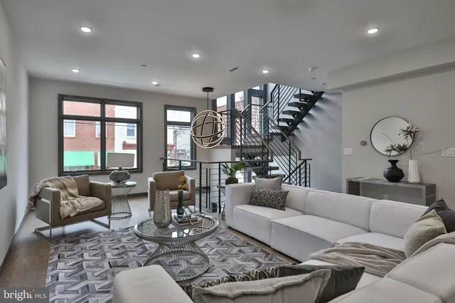 a living room with furniture kitchen view and a large window