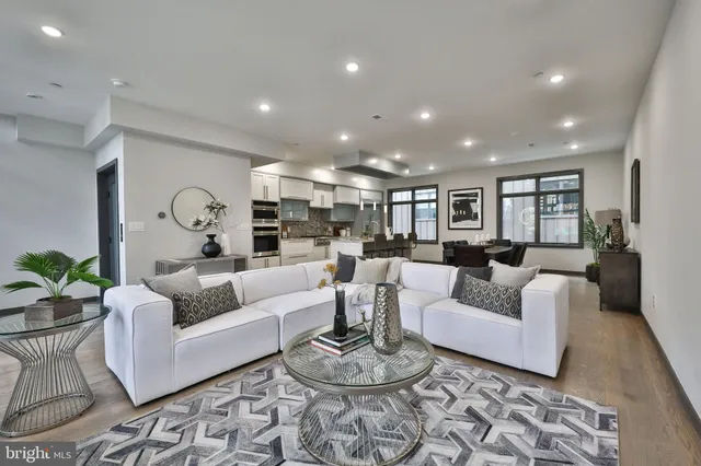 a living room with furniture and a view of kitchen