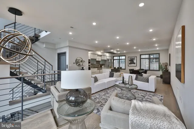 a living room with furniture and a view of kitchen
