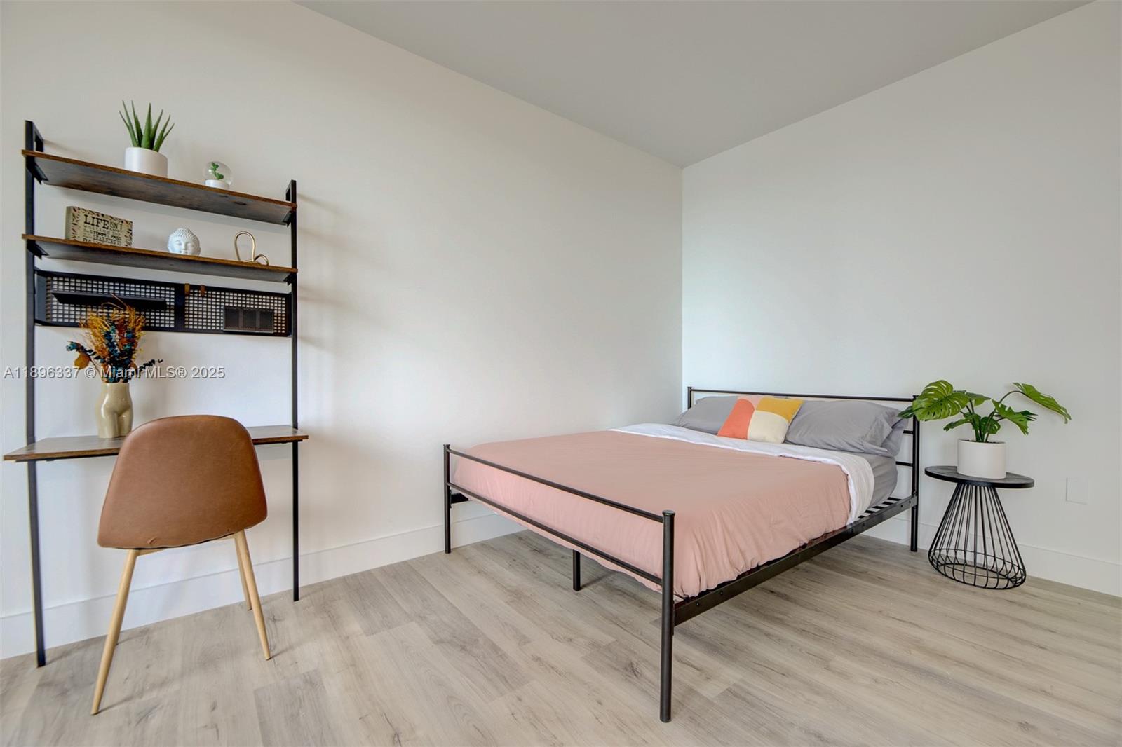 770 Northeast 69th Street, Unit 1B Miami, FL 33138 - Photo 7 of 15 a bedroom with a bed lamp and a potted plant