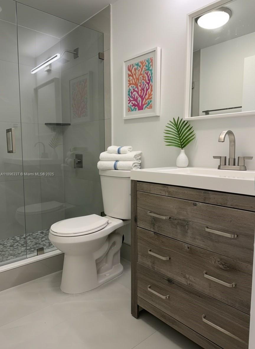 770 Northeast 69th Street, Unit 1B Miami, FL 33138 - Photo 9 of 15 a bathroom with a toilet sink and mirror