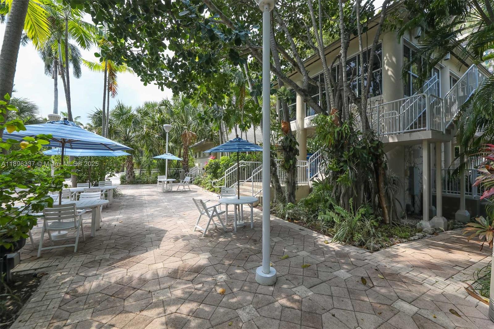 770 Northeast 69th Street, Unit 1B Miami, FL 33138 - Photo 10 of 15 a view of a patio with a table and chairs under an umbrella