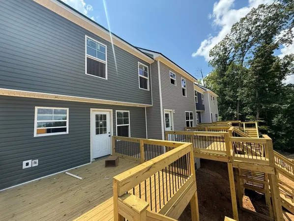 a view of a roof deck with couches chairs and wooden floor