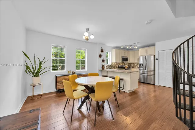 a kitchen with a table chairs refrigerator and cabinets