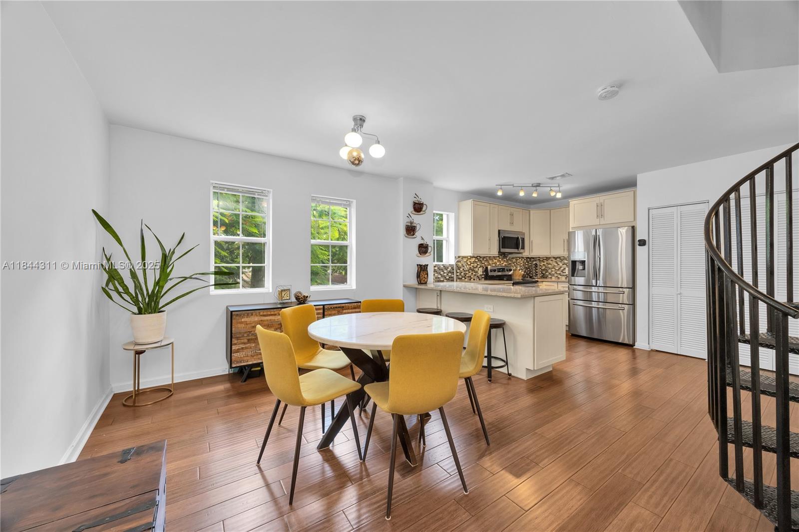 2850 Coconut Avenue, Unit 15 Miami, FL 33133 - Photo 1 of 32 a kitchen with a table chairs refrigerator and cabinets