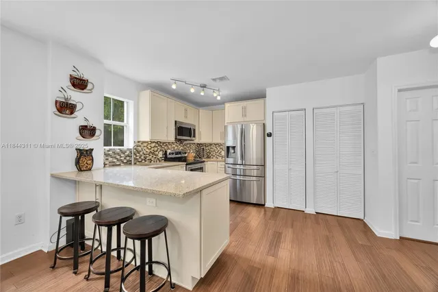 a kitchen with stainless steel appliances a refrigerator and a stove top oven
