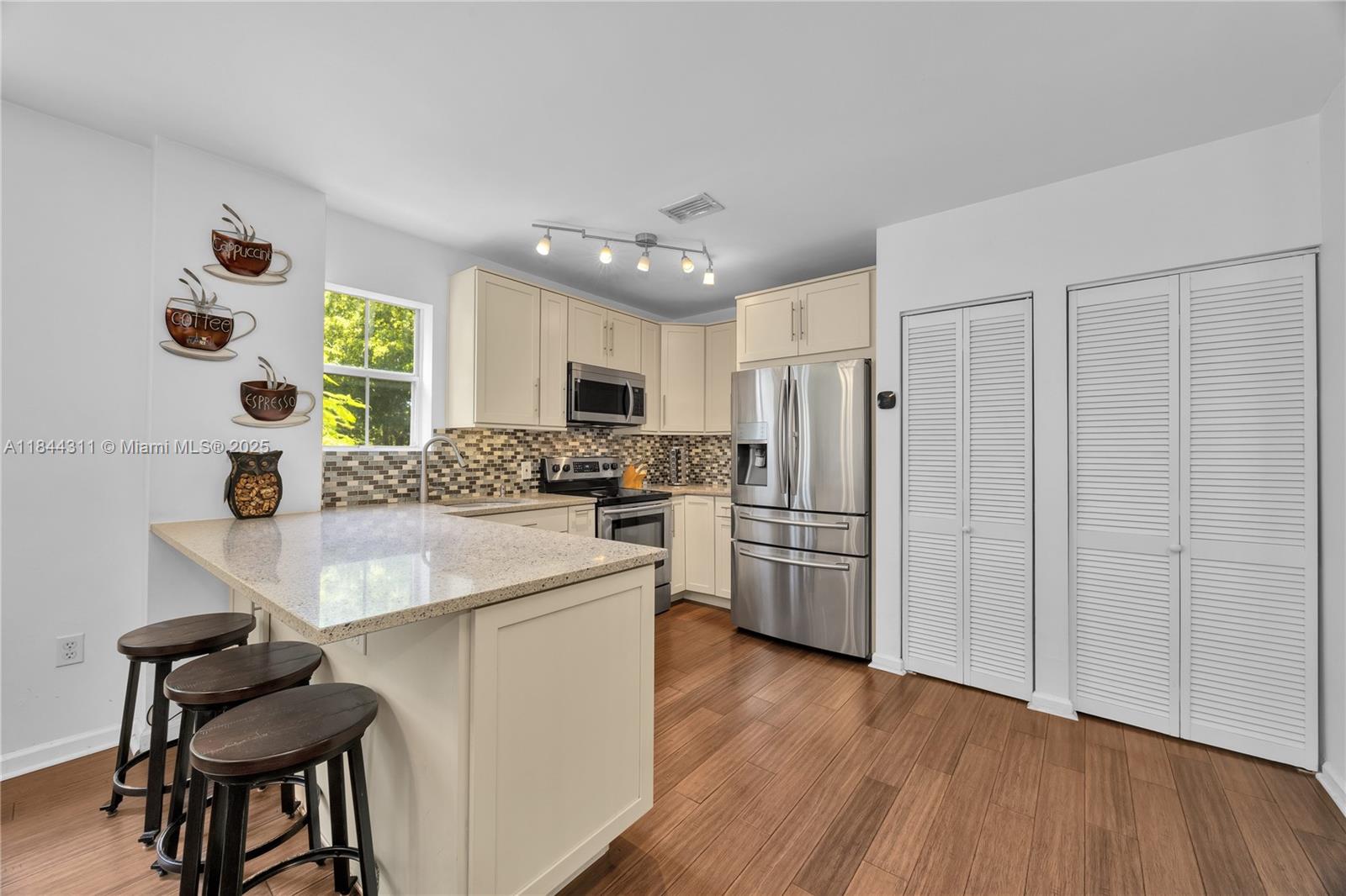 2850 Coconut Avenue, Unit 15 Miami, FL 33133 - Photo 16 of 32 a kitchen with kitchen island white cabinets and stainless steel appliances