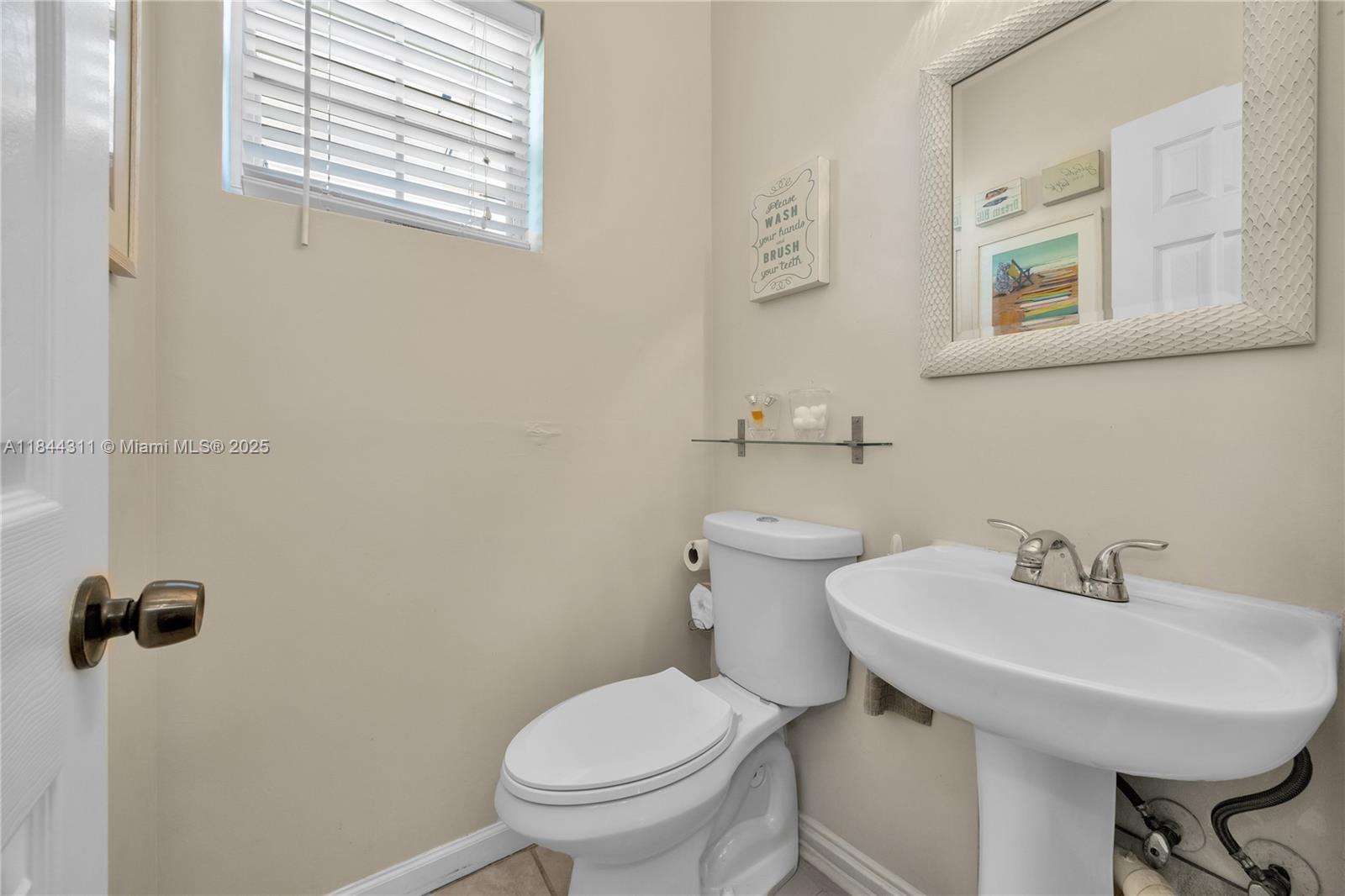 2850 Coconut Avenue, Unit 15 Miami, FL 33133 - Photo 18 of 32 a bathroom with a sink a toilet and a mirror