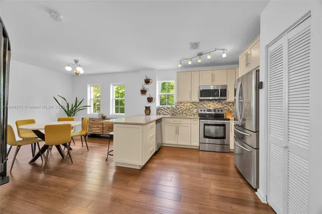 a kitchen with a refrigerator and a stove top oven