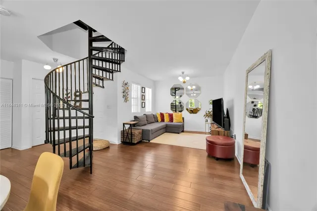 a living room with furniture stairs and a wooden floor