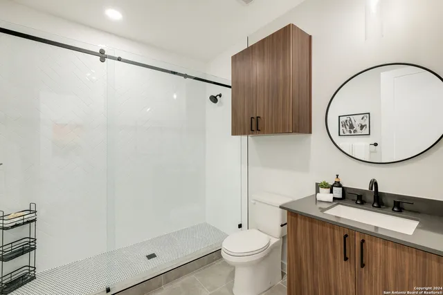 a bathroom with a sink a toilet and a mirror