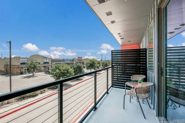 a view of a balcony with chairs and wooden fence