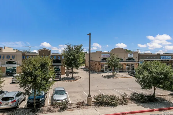 a view of a patio with dining table and chairs with plants and palm trees