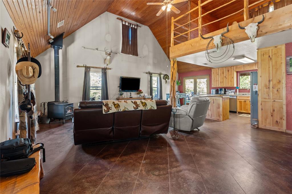 262 North Cheyenne Springtown, TX 76082 - Photo 7 of 35 Living area with wood ceiling, a wood stove, high vaulted ceiling, healthy amount of natural light, and ceiling fan