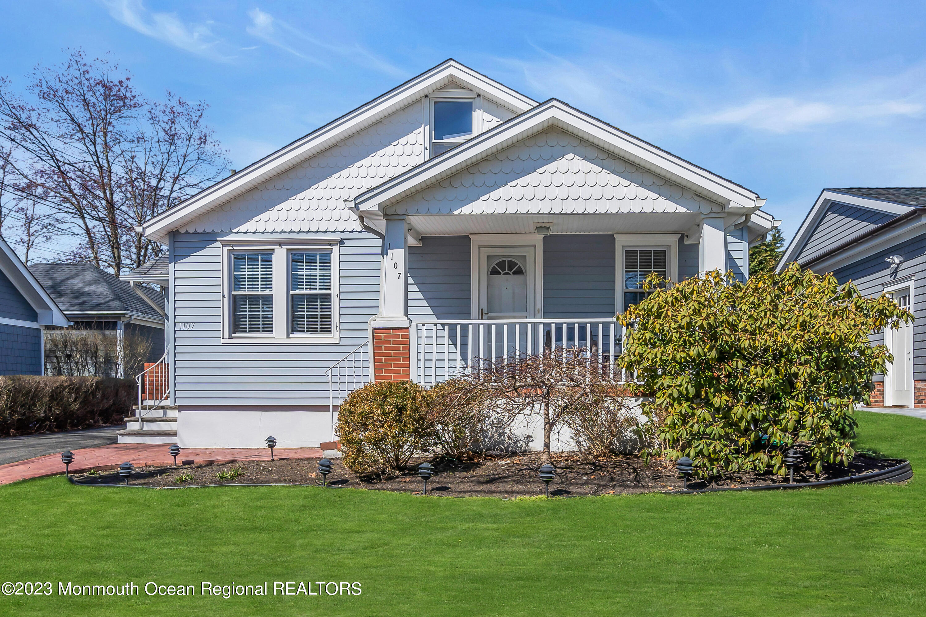 1107 5th Avenue Spring Lake, NJ 07762 - Photo 1 of 38 a front view of a house with a garden