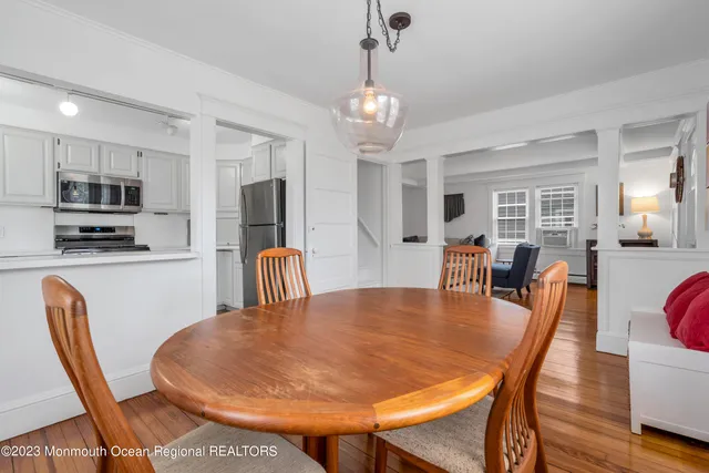 a dining room with furniture a chandelier and wooden floor