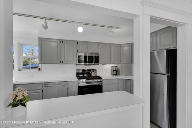 a kitchen with stainless steel appliances a refrigerator sink and white cabinets