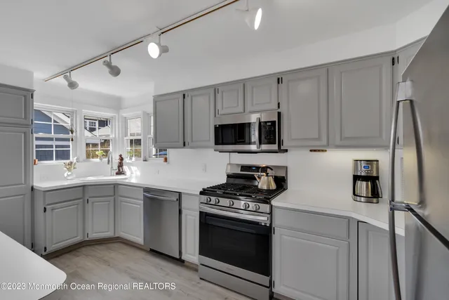 a kitchen with stainless steel appliances a sink stove and refrigerator