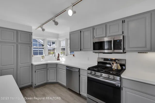a kitchen with stainless steel appliances a sink stove and microwave