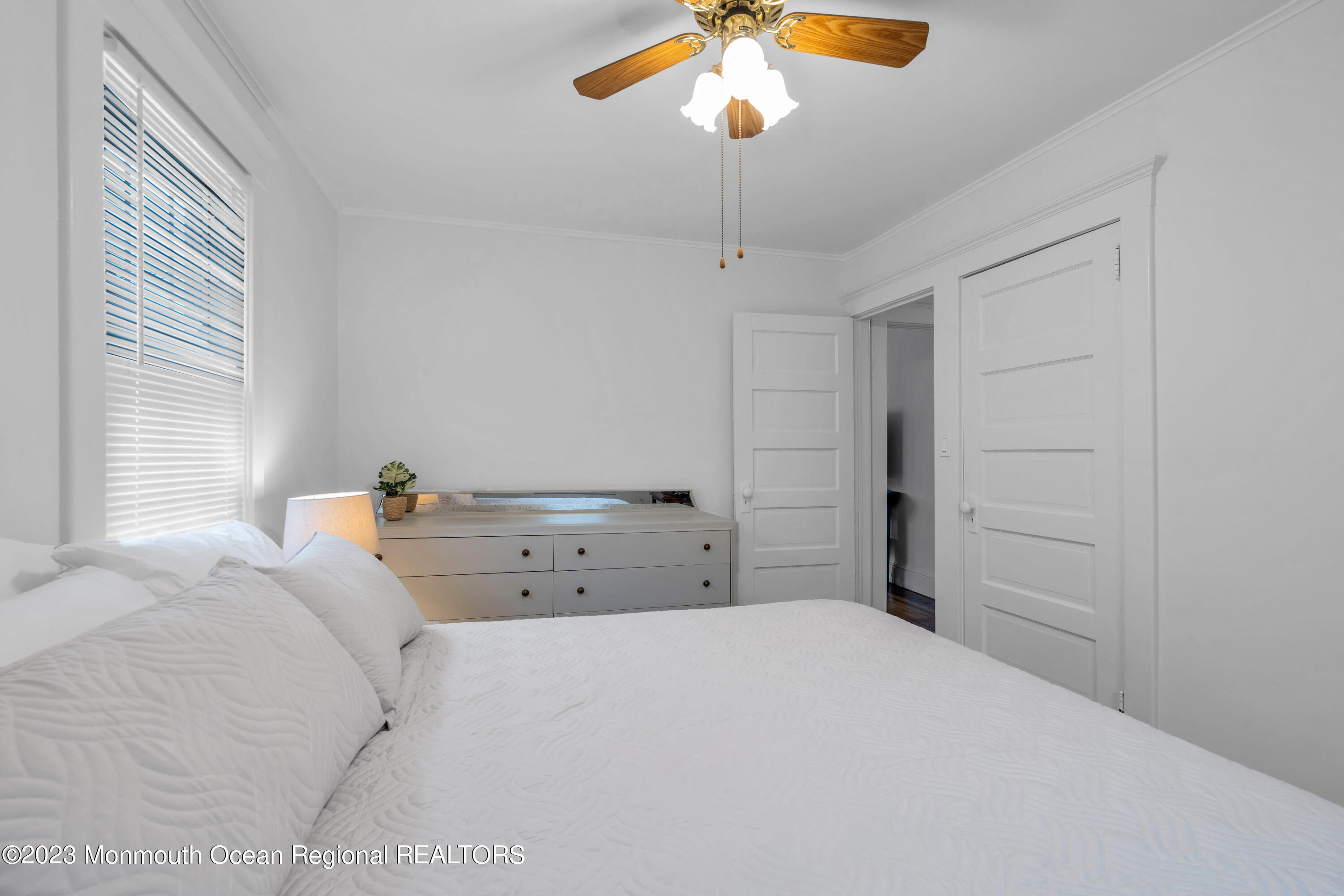 1107 5th Avenue Spring Lake, NJ 07762 - Photo 24 of 38 a bedroom with a bed and a chandelier