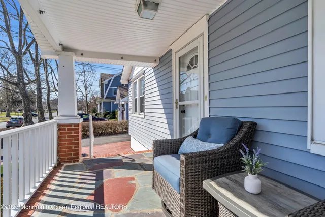 a view of a patio with couches chairs and wooden floor